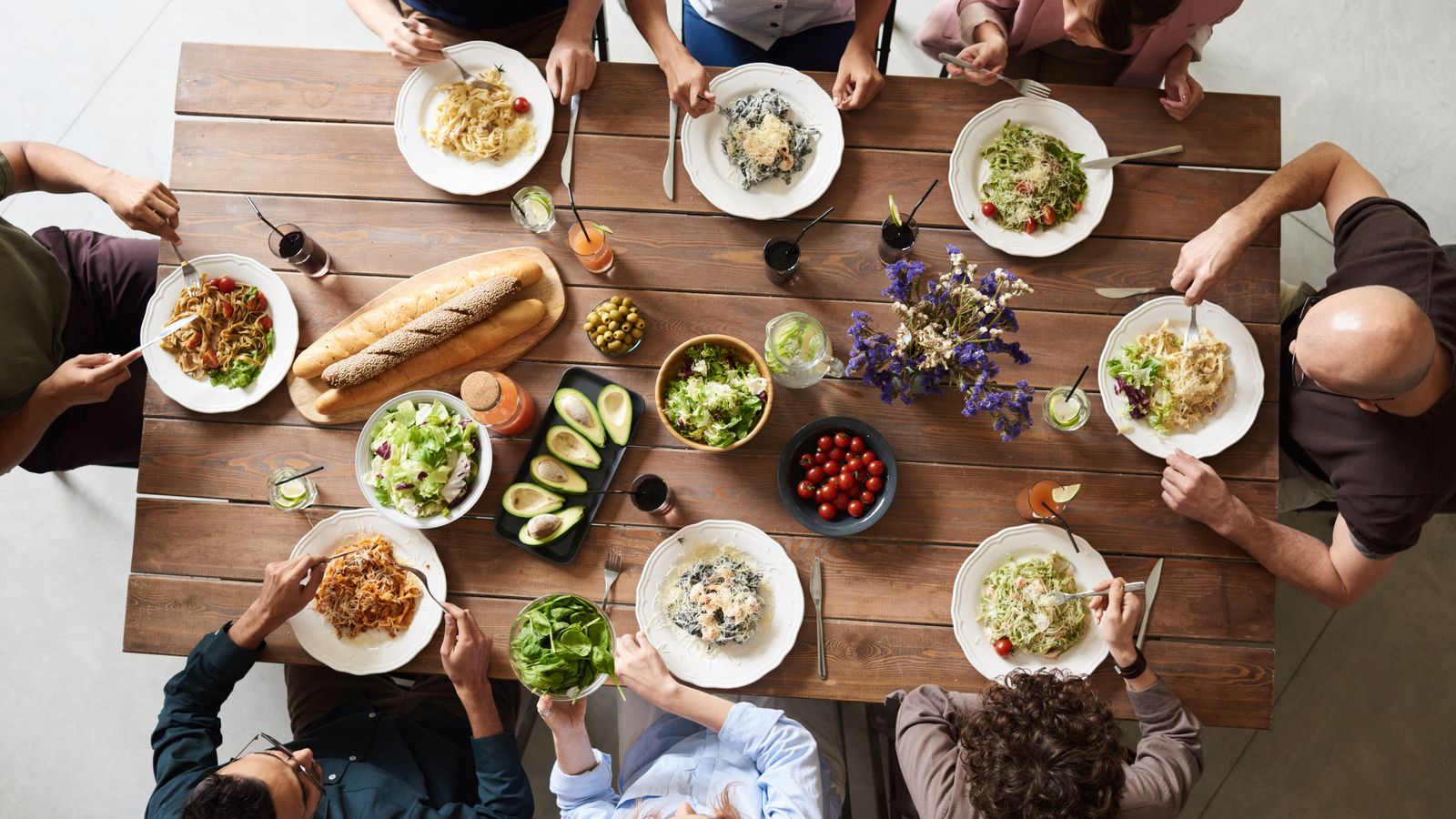 Friends sharing plates of food at a restaurant table